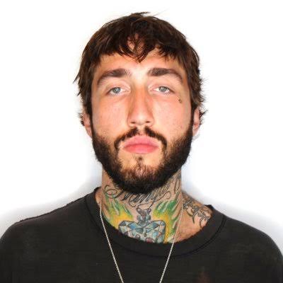 A tattooed man staring into the camera